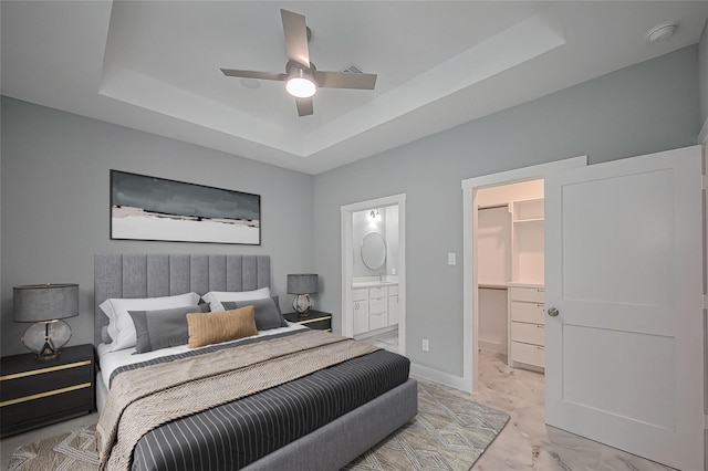 403 Smith St, Dayton, TX 77535 - bedroom with a tray ceiling, a walk in closet, light marble finish flooring, ensuite bathroom, and baseboards