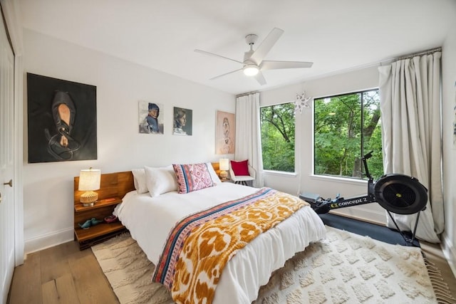 bedroom with baseboards, ceiling fan, and wood finished floors