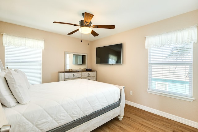 bedroom with baseboards, wood finished floors, and ceiling fan