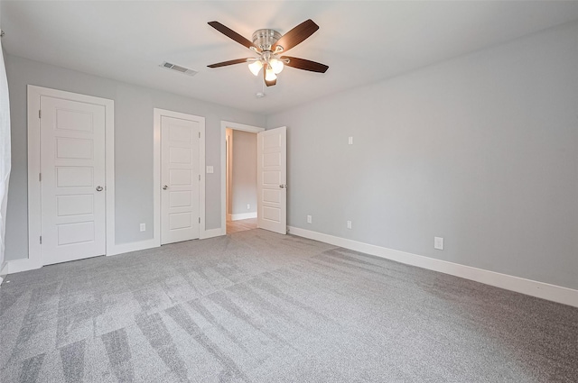 unfurnished bedroom featuring carpet floors, visible vents, ceiling fan, and baseboards