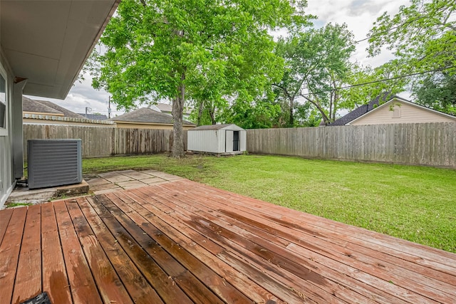deck with an outdoor structure, a storage shed, central AC, and a fenced backyard