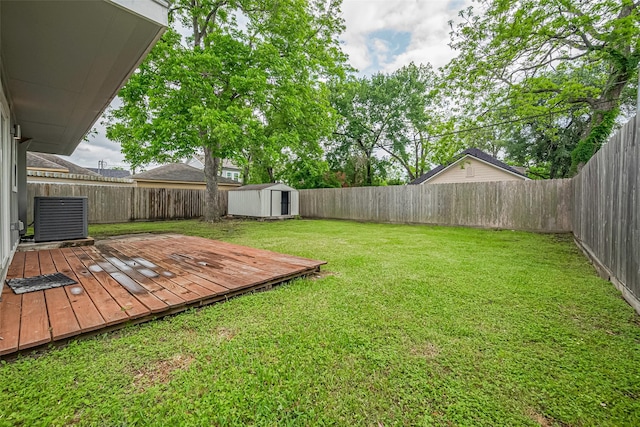 view of yard with a storage unit, central AC unit, and a fenced backyard