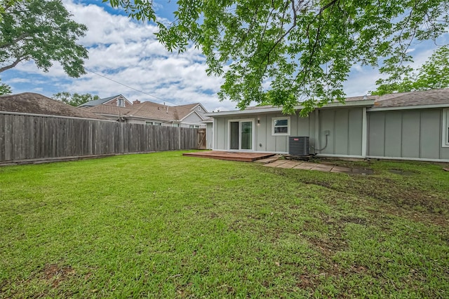 view of yard featuring central AC, a fenced backyard, and a deck