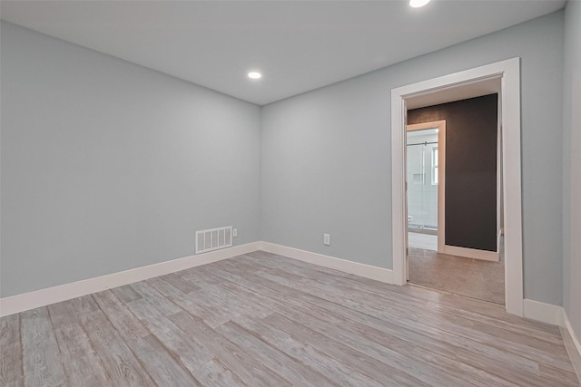 spare room with recessed lighting, visible vents, light wood-style flooring, and baseboards