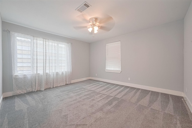 unfurnished room featuring carpet flooring, visible vents, ceiling fan, and baseboards