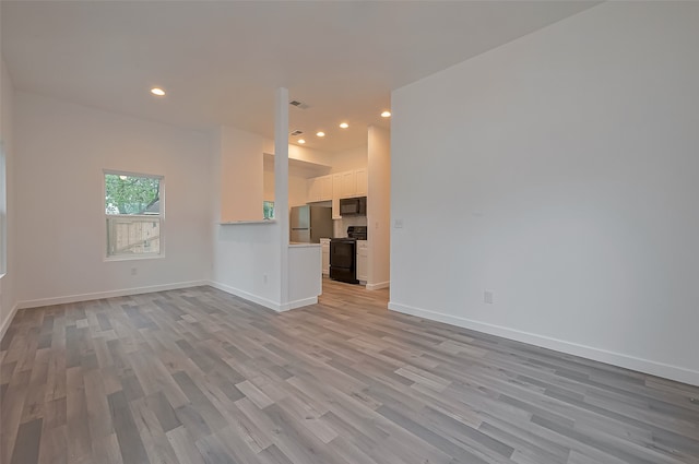 9003 Hilda St, Houston, TX 77033 - unfurnished living room featuring light wood-style flooring, recessed lighting, and baseboards