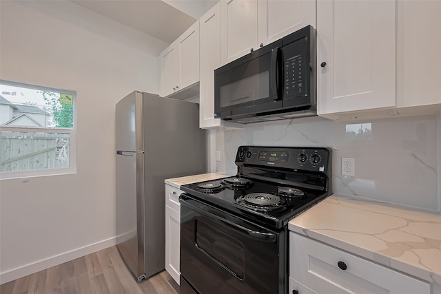 9003 Hilda St, Houston, TX 77033 - kitchen with black appliances, white cabinetry, light wood-type flooring, and light stone countertops