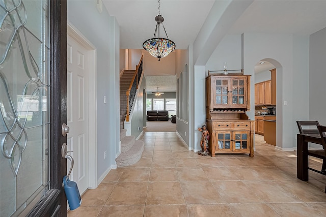1839 Pembrook Cir, Conroe, TX 77301 - entrance foyer featuring light tile patterned floors, arched walkways, stairs, and baseboards