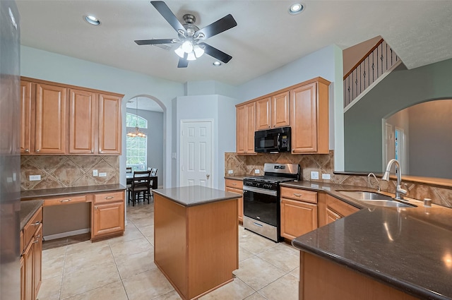 1839 Pembrook Cir, Conroe, TX 77301 - kitchen featuring a sink, black microwave, arched walkways, stainless steel gas range oven, and ceiling fan with notable chandelier