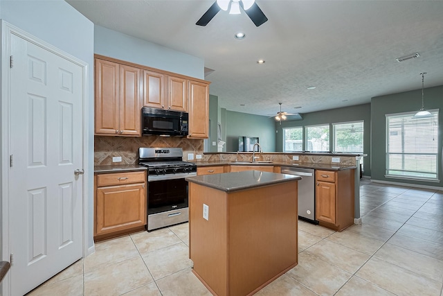 1839 Pembrook Cir, Conroe, TX 77301 - kitchen featuring appliances with stainless steel finishes, ceiling fan, a peninsula, and a center island