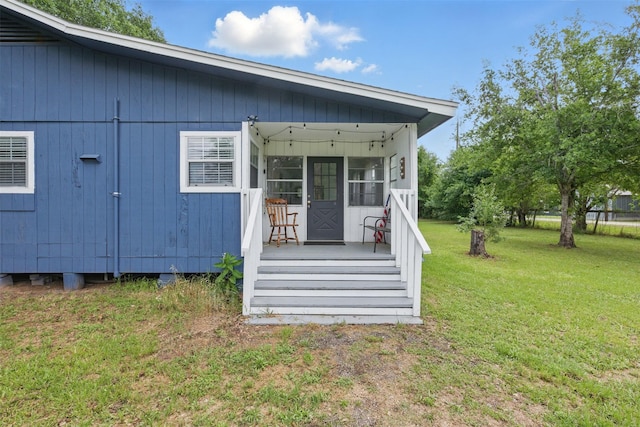 entrance to property with a lawn