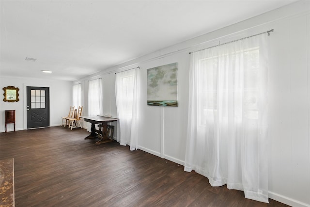 interior space featuring baseboards and dark wood-type flooring