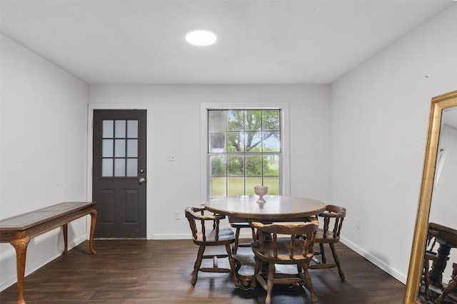 dining space featuring dark wood-style flooring and baseboards