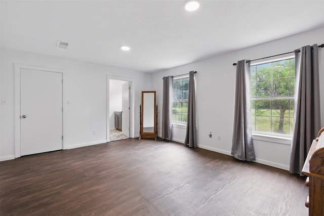 unfurnished bedroom with wood finished floors, visible vents, and baseboards