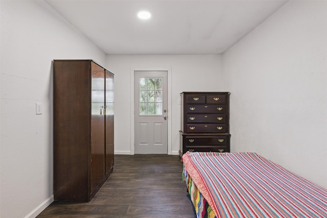 bedroom featuring baseboards and dark wood-type flooring