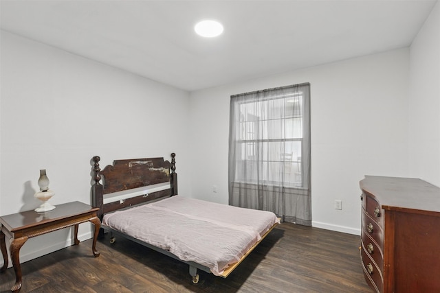 bedroom with baseboards and dark wood finished floors