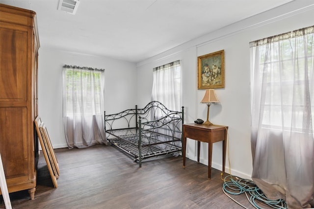 bedroom featuring visible vents, wood finished floors, and baseboards
