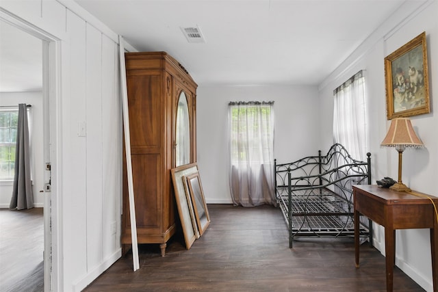 bedroom with dark wood-style floors, visible vents, multiple windows, and baseboards