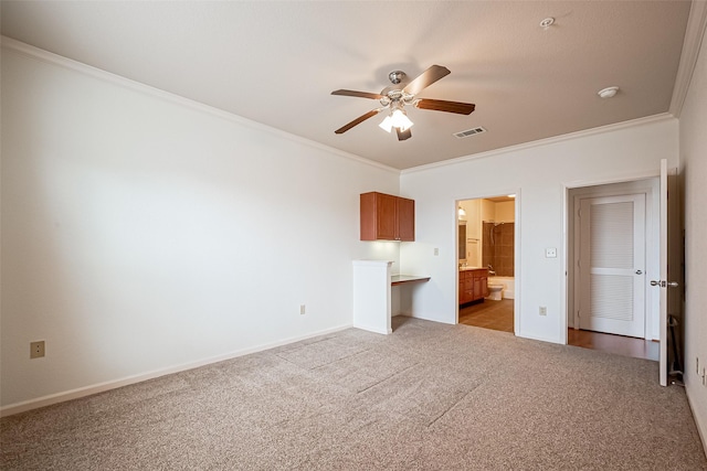 unfurnished bedroom featuring connected bathroom, crown molding, light colored carpet, visible vents, and baseboards