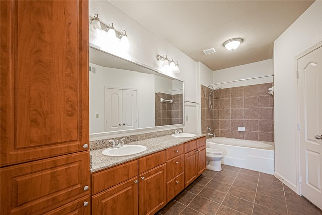 bathroom with toilet,  shower combination, tile patterned flooring, and a sink