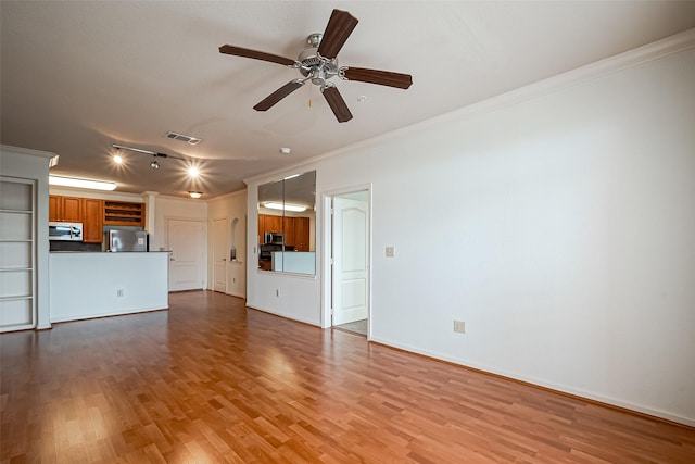 unfurnished living room featuring visible vents, ornamental molding, ceiling fan, and wood finished floors