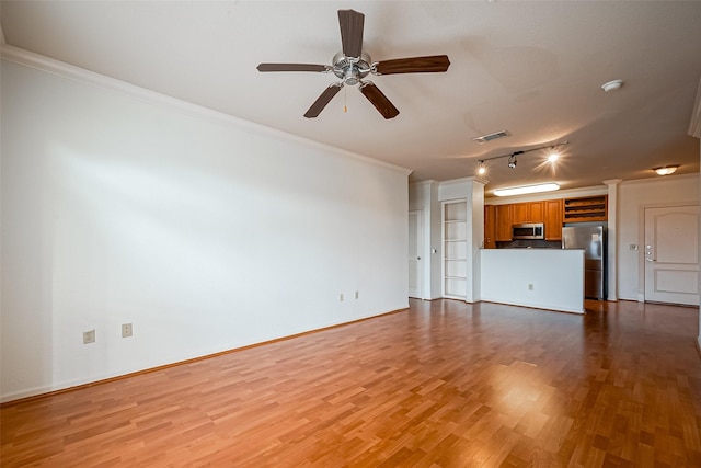 unfurnished living room featuring visible vents, wood finished floors, a ceiling fan, and crown molding