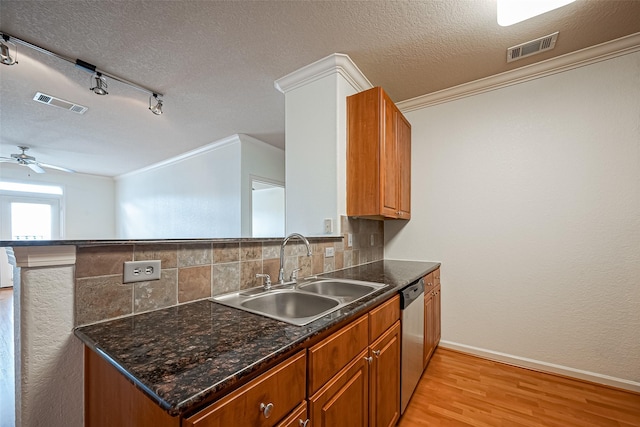 kitchen featuring visible vents, dishwasher, light wood-style flooring, and a sink