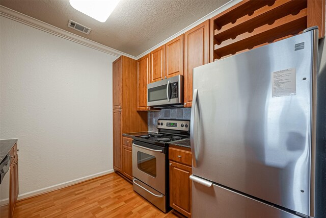 kitchen with dark countertops, visible vents, brown cabinets, and stainless steel appliances