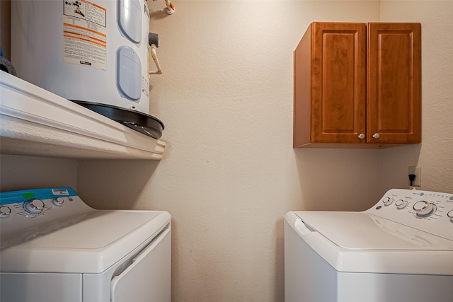 laundry area with water heater, washing machine and clothes dryer, and cabinet space