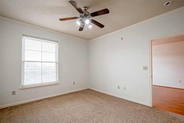 unfurnished room with crown molding, a ceiling fan, carpet floors, and baseboards