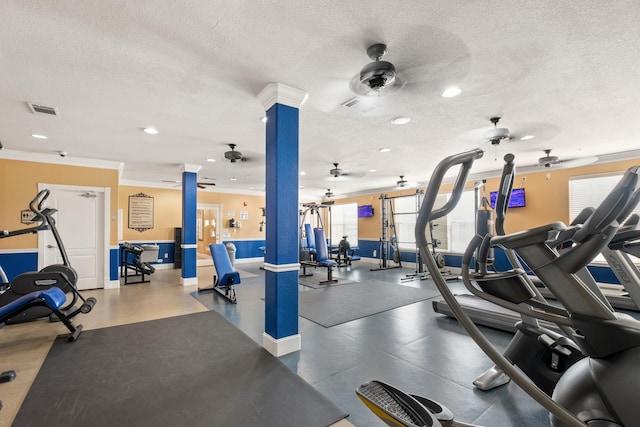 workout area featuring visible vents, a textured ceiling, and decorative columns