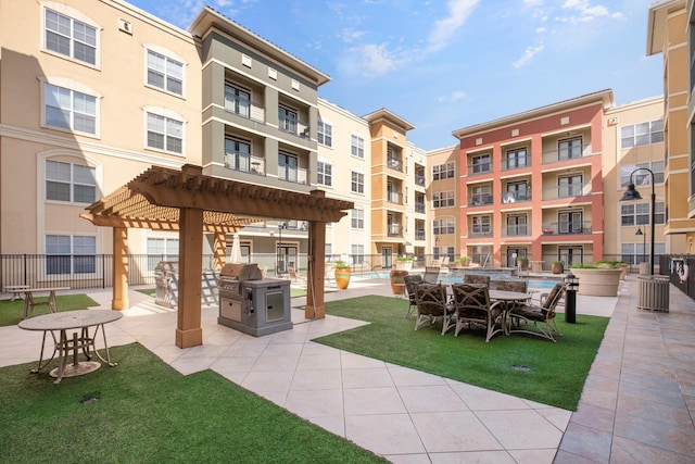 view of community with exterior kitchen, a pergola, a patio, and a pool