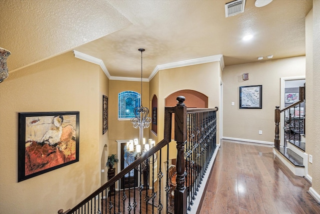 36927 Anglers Way, Pinehurst, TX 77362 - hallway with an upstairs landing, a chandelier, hardwood / wood-style flooring, baseboards, and arched walkways