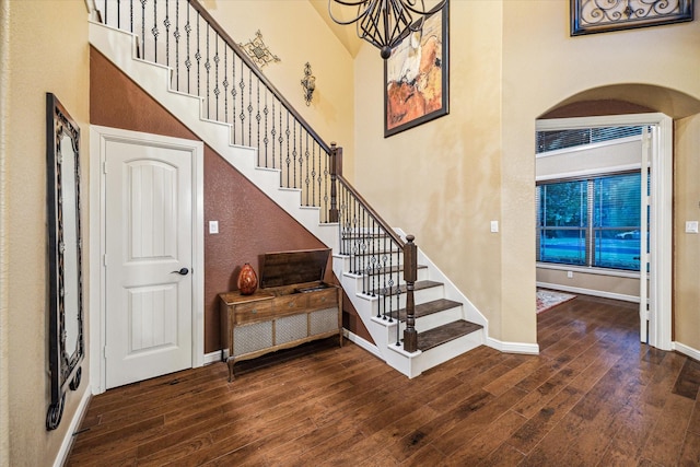 36927 Anglers Way, Pinehurst, TX 77362 - stairway featuring hardwood / wood-style flooring, a chandelier, baseboards, arched walkways, and a towering ceiling