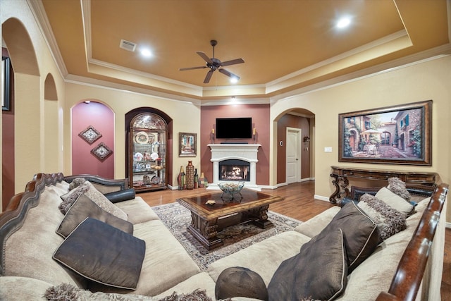 36927 Anglers Way, Pinehurst, TX 77362 - living room with a tray ceiling, arched walkways, a ceiling fan, crown molding, and wood finished floors
