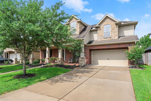 view of front of home with covered porch, driveway, a front yard, a garage, and brick siding