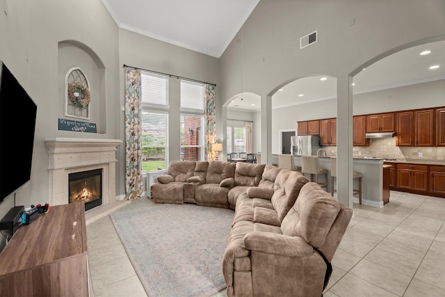 1619 Julia Park Dr, Spring, TX 77386 - living room with high vaulted ceiling, light tile patterned floors, ornamental molding, a glass covered fireplace, and recessed lighting