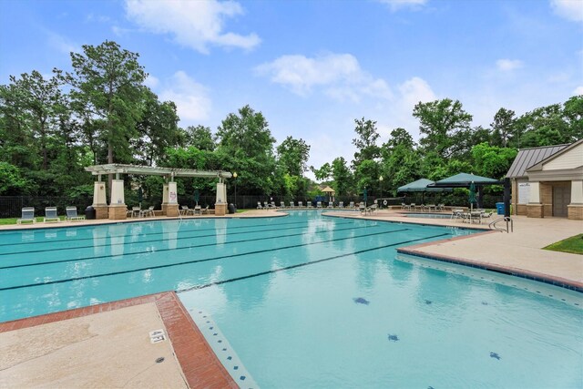 pool with a patio area, fence, and a pergola