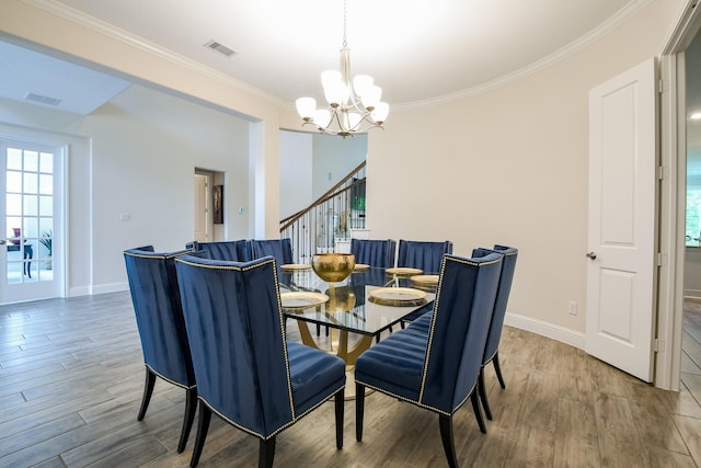 dining space with an inviting chandelier, wood finished floors, a healthy amount of sunlight, and ornamental molding