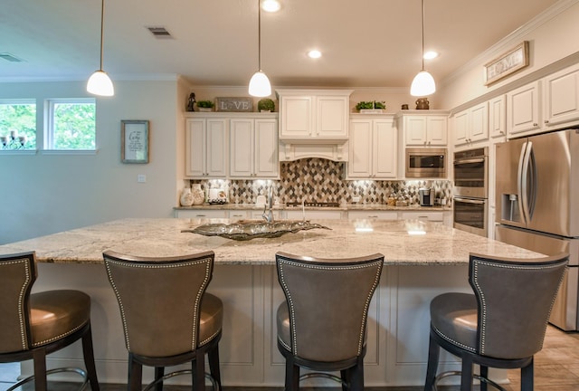 kitchen with light stone counters, a spacious island, decorative backsplash, appliances with stainless steel finishes, and crown molding