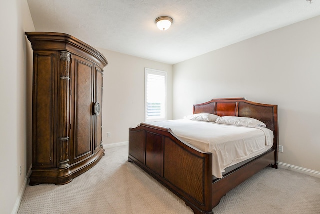 bedroom with baseboards and light carpet