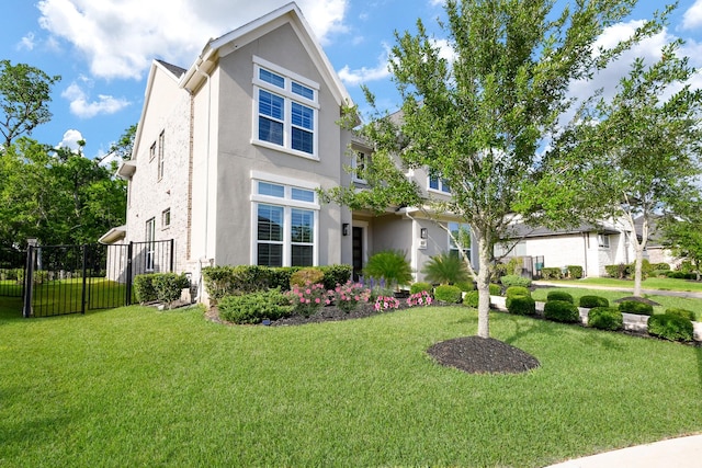 traditional-style home featuring stucco siding, fence, and a front lawn