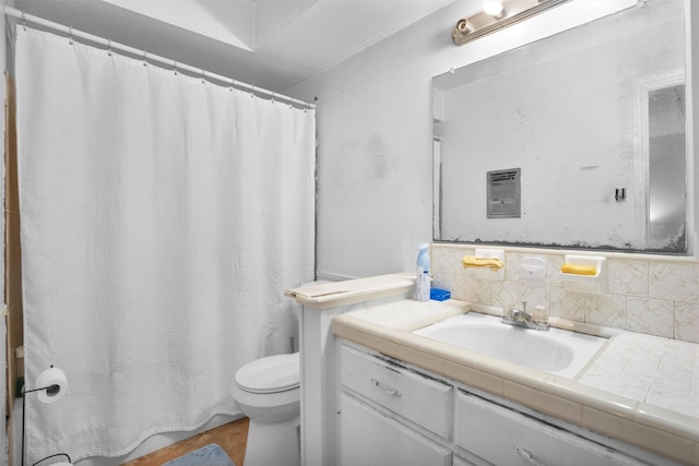 bathroom with toilet, visible vents, vanity, and decorative backsplash