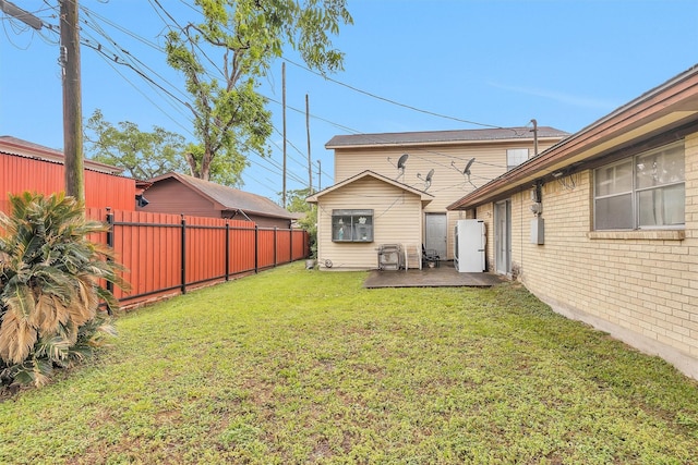 back of property with a lawn, a patio, brick siding, and fence
