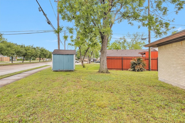 view of yard featuring an outbuilding, driveway, and a storage shed