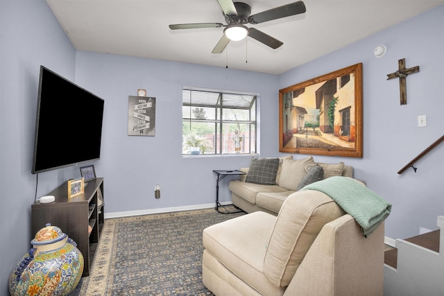 living area featuring a ceiling fan and baseboards