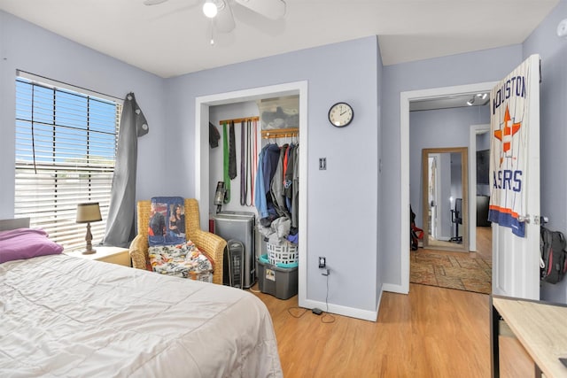 bedroom with ceiling fan, light wood-type flooring, a closet, and baseboards