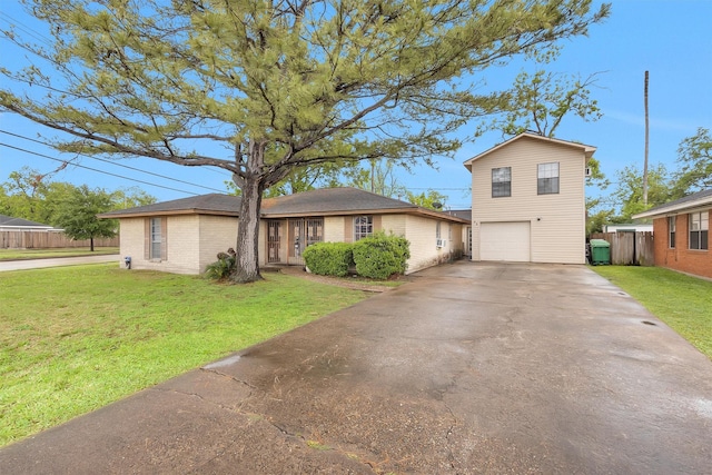 view of front facade with driveway, fence, a front yard, and an attached garage