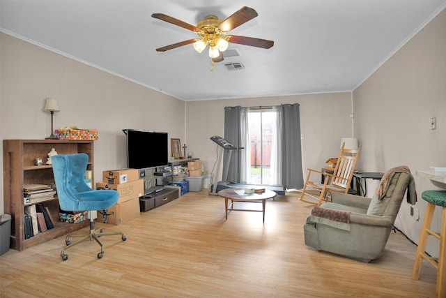 living room with ornamental molding, wood finished floors, a ceiling fan, and visible vents