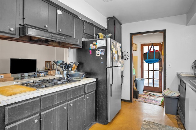 kitchen featuring appliances with stainless steel finishes, finished concrete floors, light countertops, and under cabinet range hood
